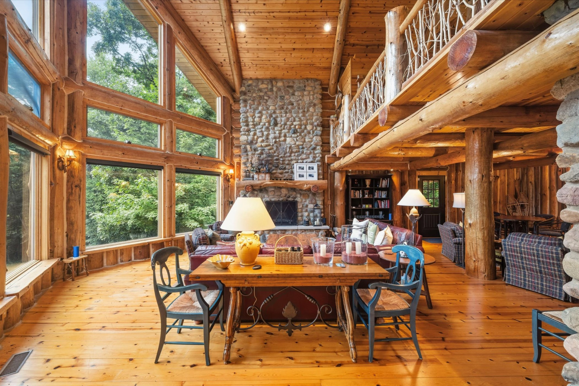 Two-story great room with floor-to-ceiling windows and stone fireplace