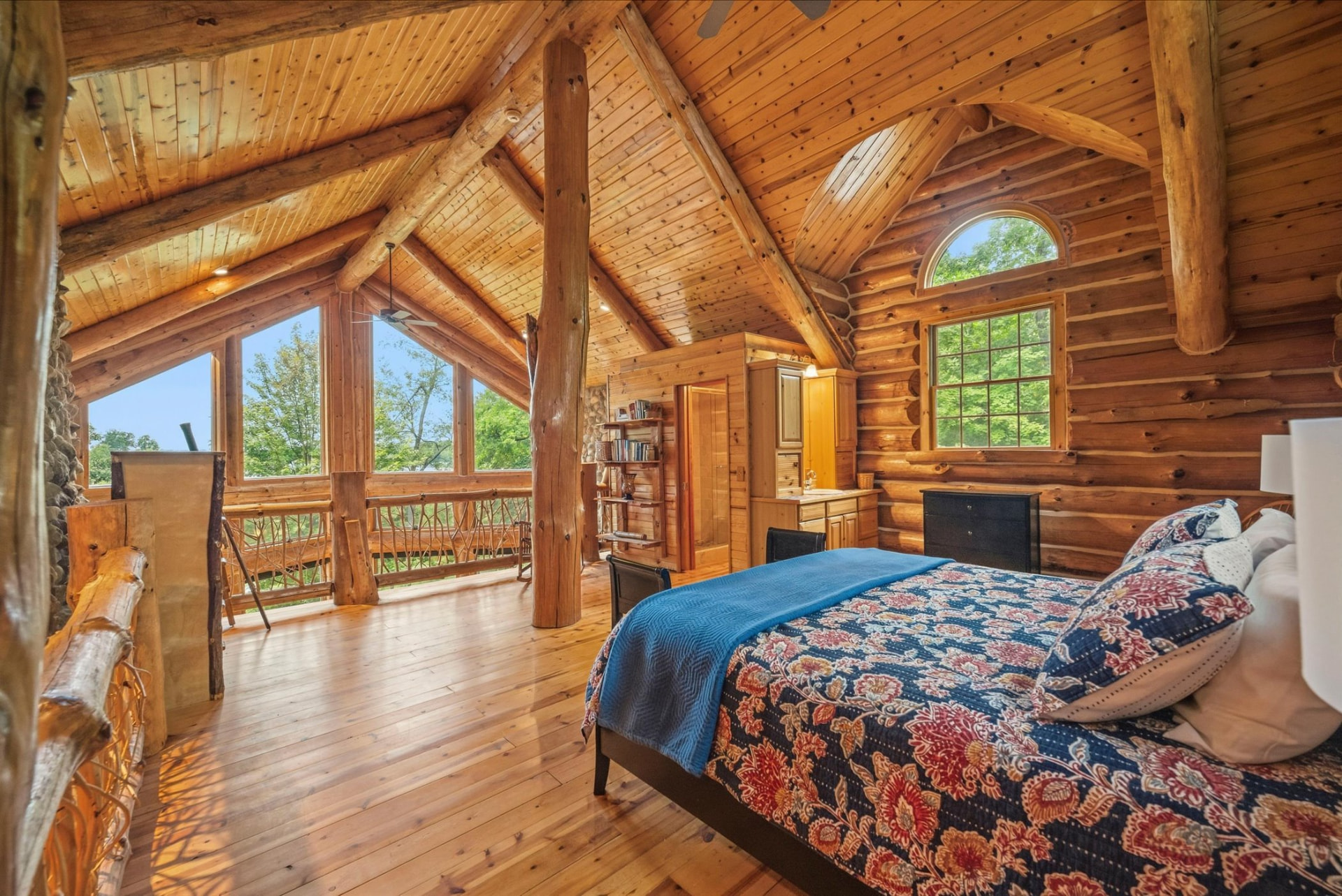 Vaulted primary suite with arched window and private balcony